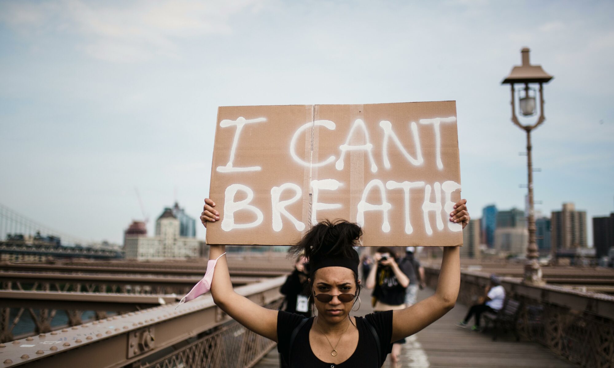 Militante brandissant une pancarte "I can't breathe".